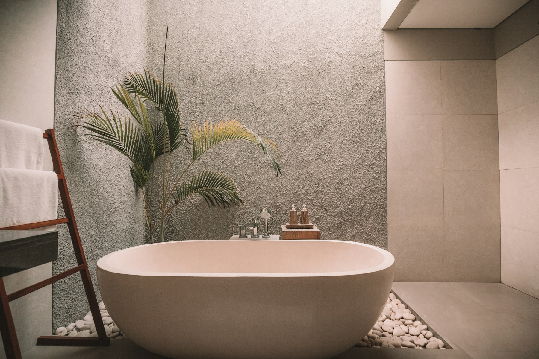 A quiet spa room with stone, linen, and greenery